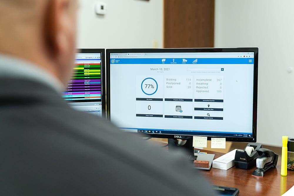 over shoulder shot of man looking at desktop computer