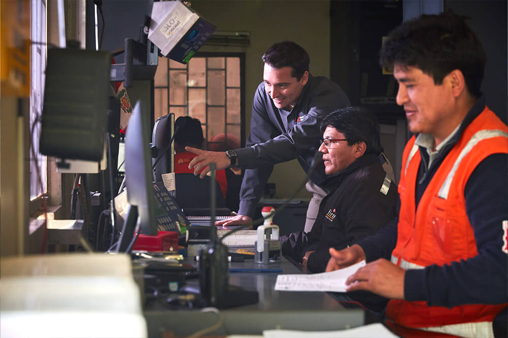 man in dispatch office pointing at computer screen